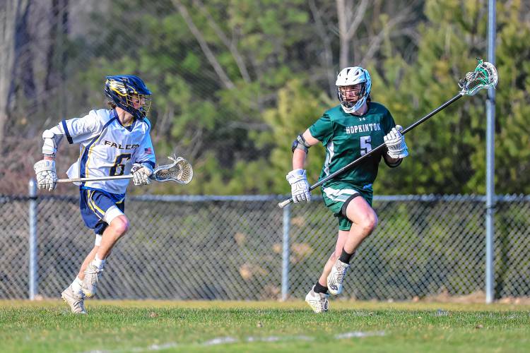 Hopkinton captain Cam Bassett looks to move the ball downfield as Billy Smethurst tries to chase him down during Tuesday’s season-opening win for the Hawks over Bow. 