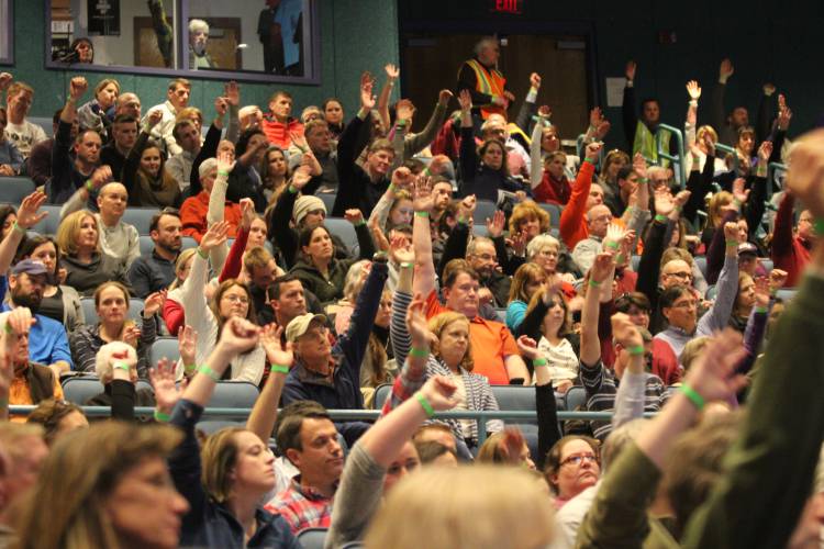 Bow residents vote in favor of amending the Bow Budget Committee's recommended operating budget for the school district by over 750,000 during the Bow School District's town meeting Friday night.