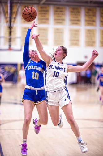 Kearsarge guard Ava Shapiro (left) drives against St. Thomas guard Emma Toriello during the first half of a Division III girls' basketball semifinal at Bow High School on Wednesday.