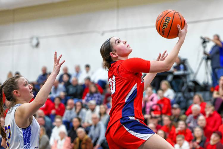 John Stark’s Abby Duclos stares up at the basket as she attempts a reverse layup during Wednesday night’s D-II semifinal at Salem High School.
