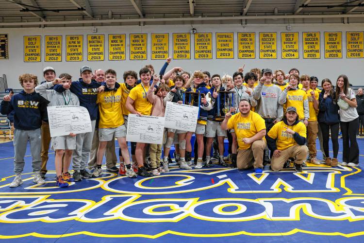 The Bow High School wrestling team celebrates with its hardware after the Falcons won several awards and the team title at the NHIAA Division III wrestling championship on their home mats on Saturday.