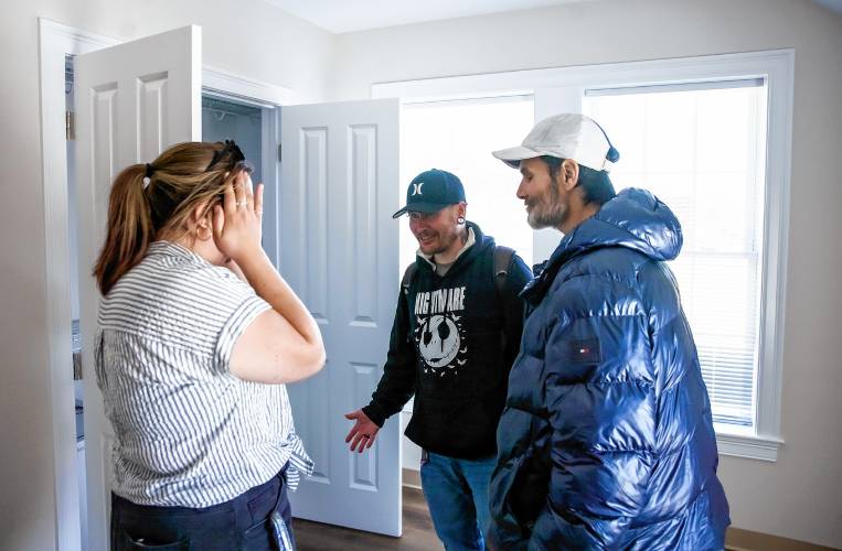 Larry Regan (right) celebrates  with David Lee Josselyn (center) and  Connor Spern of the Concord Coalition to End Homelessness as they inspect one of the eight apartments that will house the homeless at the grand opening  at the Pleasant Street complex on Tuesday, April 23, 2024. Josselyn and Regan have apartments now.