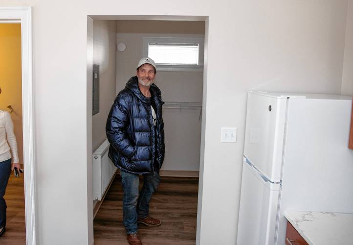 Larry Regan looks over the apartment that he will be living  at the grand opening  at the Pleasant Street complex on Tuesday, April 23, 2024. 