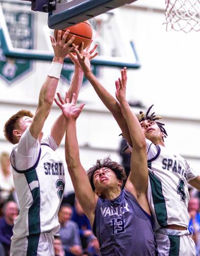 Merrimack Valley guard Trevor Simonds (13) fights for a rebound against Pembroke forwards Devin Riel (left) and Javien Sinclair during the second half of the Division II quarterfinal game on Friday night.