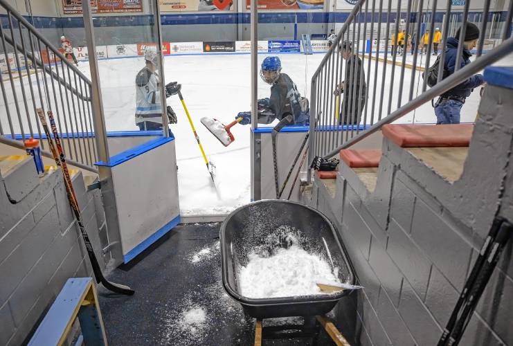 Players exchange their sticks for shovels as they clean up the rink in between games at the Black Ice Tournament at Tri-Town Arena in Hooksett on Friday, March 22, 2024.