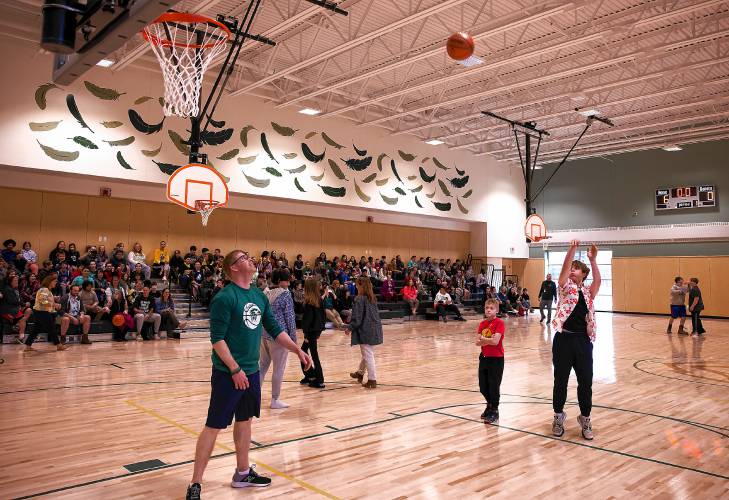 Allenstown student Gavan Foskitt (right) shoots a basketball in the new gymnasium as part of the tour of the new Allenstown Community School on Thursday morning, April 18, 2024.