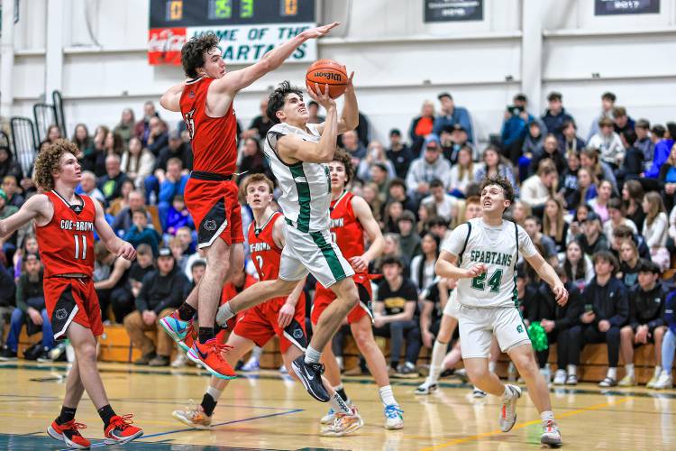 Pembroke senior captain Joe Fitzgerald attempts a shot as Coe-Brown's Jack Matson flies in behind him during their matchup on Mon. Feb. 19, 2024.