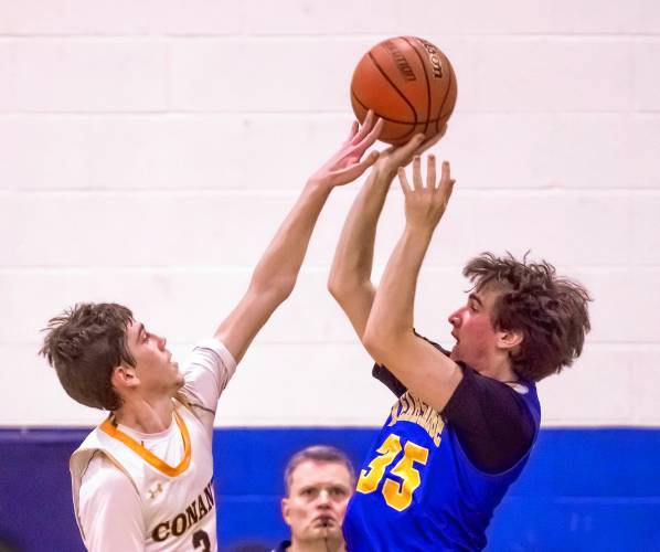 Conant guard Manny Hodgson partially blocks a shot of Kearsarge guard Eddie Kinzer at the buzzer to end the first half on Tuesday night, February 20, 2024 at Bow High School at the D-III semifinals.