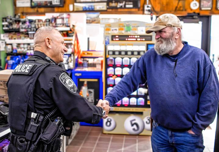 Pittsfield police officer Don Bolduc greets James Wesson at the Bell Brothers convenience store in downtown Pittsfield on Feb. 8. Wesson remembered that Bolduc recently passed on giving him a ticket when Wesson said he couldn’t afford to pay the fine.