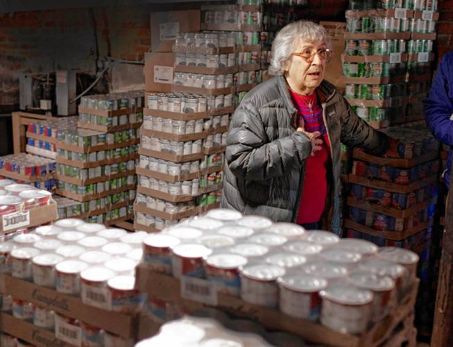 Mary Jane Bailey shows the present Christ the King food pantry where food is brought out of the basement in a small house on the campus of the Catholic Church on South Main Street in Concord. Bailey started volunteering in the pantry 40 years ago and wants to see the new one built in her lifetime.