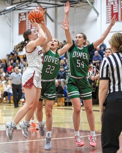 Concord’s Delaney Duford floats up a shot as Dover’s Tory Vitko (22) and Lily Nossiff (54) leap for a block during Friday’s win for the Tide.