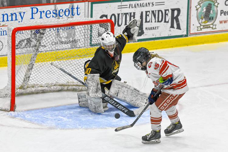 Hailey Pinette (15) tries to control a rolling puck for the Tide as Manchester goalie Chloe Gilroy prepares to make a save during Concord’s 5-1 win on Wednesday.