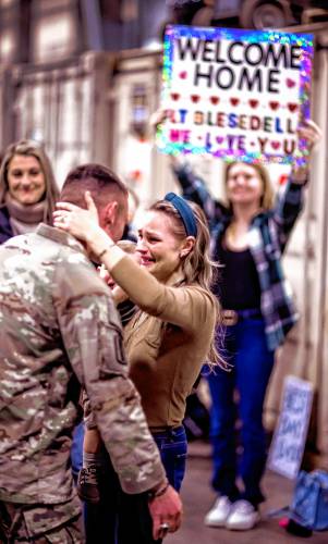 Brielle Torressen of Belmont and her son, Revere, welcomes her husband, Captain Andrew Torressen of the New Hampshire Army National Guard 3rd Battalion, 197th Field Artillery Regiment back from their 10-month deployment to the Middle East at the Manchester Armory on Thursday night, February 8,2024.  