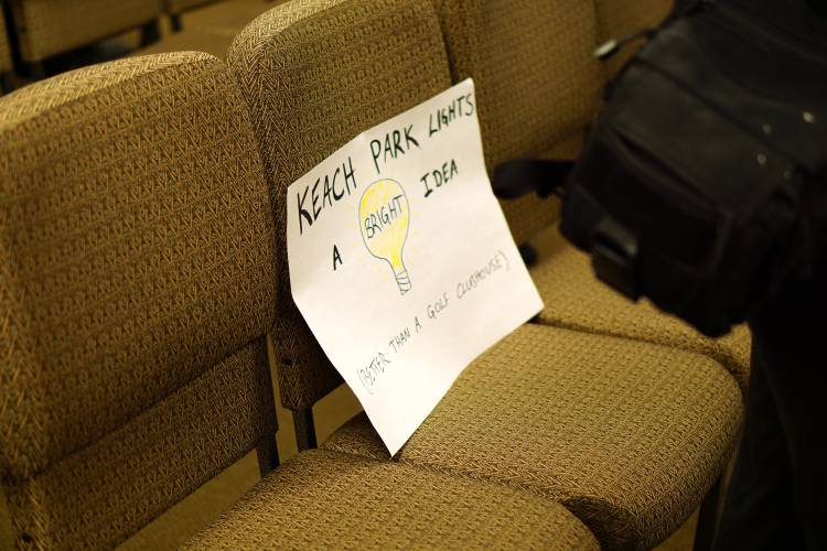 Residents held signs asking councilors to follow through on the Keach Park Lights project, comparing it to the golf clubhouse at the heart of the current ethics complaint.