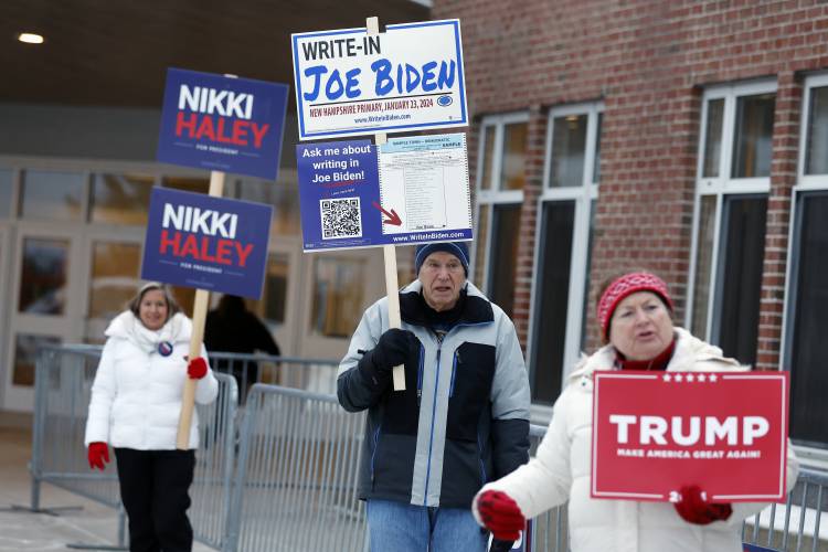 Candidate supporters stand outside the Windham High School polling place in the presidential primary election, Tuesday, Jan. 23, 2024, in Windham, N.H. (AP Photo/Michael Dwyer)
