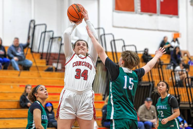 Concord’s Sofia Payne (34) goes up for a shot while being tightly marked by Manchester Central-West on Monday at Concord High School. Payne scored 20 points and grabbed 10 rebounds to lead Concord to its fourth straight victory. 