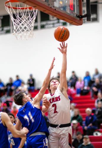 Coe-Brown guard James McKane goes up against Pelham forward Justin Bowlan during the fourth quarter of Tuesday’s game.