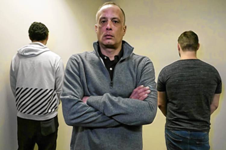 David Meehan, center, the lead plaintiff in a class-action lawsuit accusing the State of New Hampshire of covering up decades of sexual, physical and emotional abuse at its youth detention center, poses with two other victims who did not want to be identified, at his lawyer's office on Feb. 18, 2021, in Portsmouth, N.H.