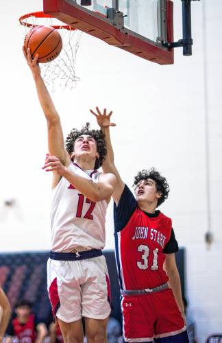 Coe-Brown forward Quinn Salter goes up for a lay up against John Stark guard Reagan Webb during the first half on Tuesday night, February 6, 2024.
