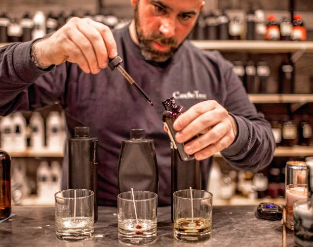Ross Mingarelli uses a dropper to create scents for his speciality candles at is downtown Candle Tree Soy Candle shop. Mingarelli has over 600 different scents for his candles.