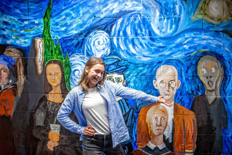 Caia Kimball, a freshman at Concord High School, stands in front of one of the many murals around the school on Friday, Dec. 8. Kimball wanted to foster the creative arts so she decided to give back resources to the art department Broken Ground School where she went to school.