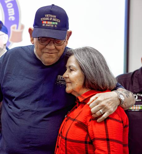 Nancy Warner gets a hug from Bob Blairs from the Vietnam Veterans of America Chapter 41 at the New Hampshire Veterans Home Vietnam War Veterans Day ceremony in Tilton on Friday.