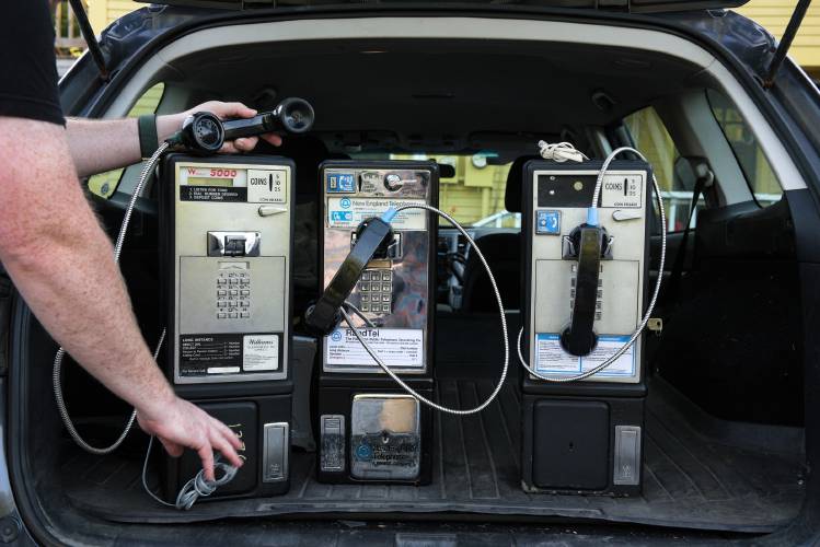 Above: Patrick Schlott, an electrical engineer who has a fascination with the history of telecommunications, loads his collection of pay phones into his car while preparing to move from his North Tunbridge apartment to a new home in Williamstown last month. Schlott has been outfitting the phones with analog-to-digital adapters with plans to install them as free public phones at businesses in rural cellular dead zones. “It’s partially self-serving because I like playing with old phone equipment,” said Schlott. But he wants his hobby to educate people and provide a public service.  Top right: Schlott updates the software for his Randolph Telephone Operating Co. phone at the North Tunbridge General Store. Calls are routed through the store’s internet and Schlott himself pays a voice over internet protocol (VoIP) provider for the phone line and calls made. Above right: Lois and Michael Gross, owners of the North Tunbridge General Store. “Part of everything we do here, including the phone, is out of service to the community,” said Michael Gross. 