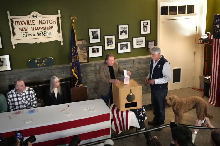 Les Otten, far right, has his vote inserted into the ballot box by town moderator Tom Tillotson shortly after midnight in the presidential primary election, Tuesday, Jan. 23, 2024, in Dixville Notch, N.H. All six voters selected Nikki Haley. (AP Photo/Robert F. Bukaty)