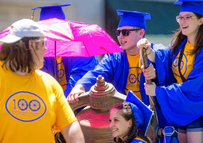  Graduate Kadance Laro (right) rings an antique school bell on Thursday as classmates  parade through downtown Franklin.