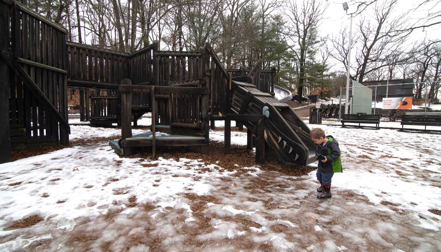 Myles Mishkit, 3, walks gingerly on the snow-covered wood chips at the playground at White Park in Concord on Tuesday, December 10, 2019. Myles came to the park with his mother and little brother. 