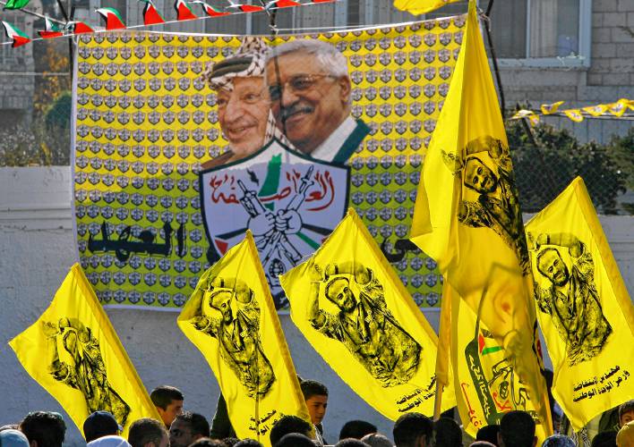 In this Jan. 3, 2008 file photo Palestinian Fatah supporters hold up flags with the picture of the popular Fatah leader jailed in Israel, Marwan Barghouti, as they celebrate at a rally marking the movement's 43rd anniversary in the West Bank city of Ramallah. 