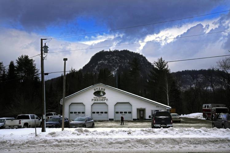 A voter watches her footing as she walks across the snow-covered parking lot after voting in the presidential primary election, Tuesday, Jan. 23, 2024, in Stark, N.H. The town's polling site, located in the volunteer fire dept., sits is in the shadow of Devil's Slide Mountain. (AP Photo/Robert F. Bukaty)