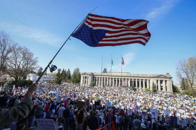 Lee Telnack waves an upside-down American flag on a fish pole during a Lee Telnack waves an upside-down American flag on a fish pole during a