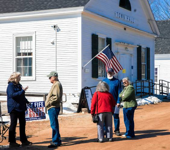 Select Board candidate Rose Fife (left), talks with Dave Merwin as Gail Henry (center) talks with Ed and Linda Denoncourt outside the Salisbury Town Hall during lunchtime voting on Tuesday, March 11, 2025.